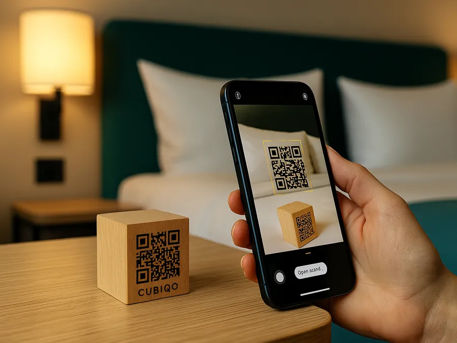 En träkub med QR-kod på ett nattduksbord skannas med en telefon.